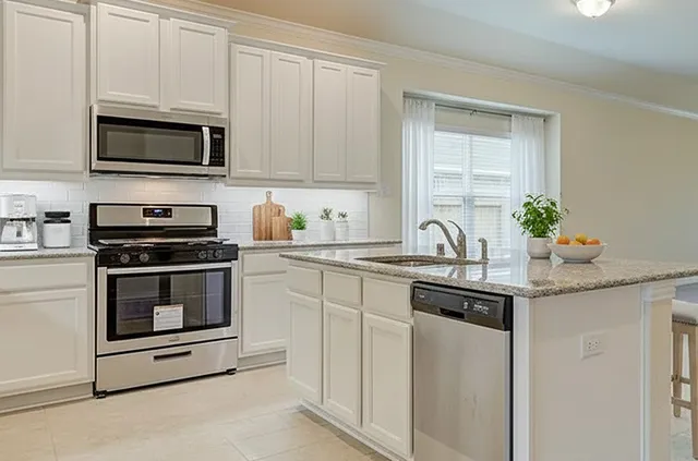 a kitchen with white cabinets and appliances