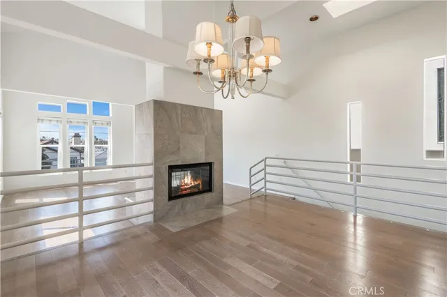a living room with wooden floor a fireplace and a window