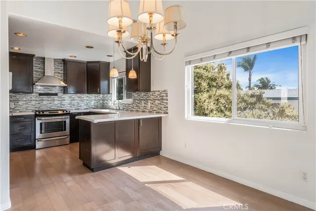 a kitchen with a stove a sink and a chandelier