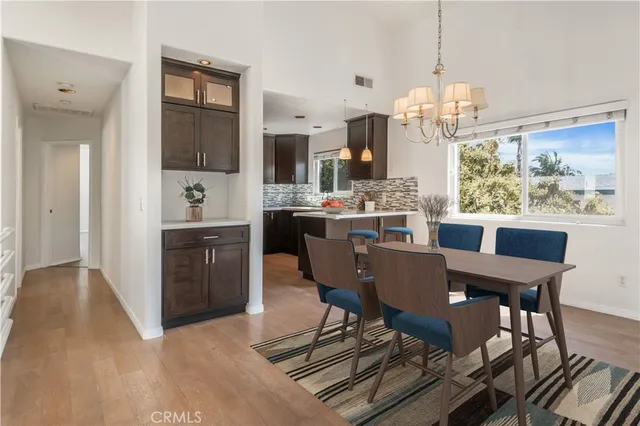 a view of a dining room with furniture a chandelier and wooden floor