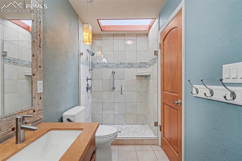 5301 Pinon Valley Road Colorado Springs, CO 80919 - Photo 16 of 27 a bathroom with a sink toilet and shower