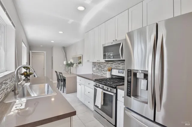 a kitchen with stainless steel appliances granite countertop a refrigerator sink and stove