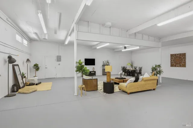 a living room with fireplace furniture and a view of kitchen
