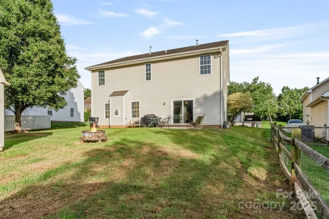 a view of a house with backyard and a tree