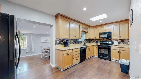 a kitchen with a refrigerator stove top oven and sink