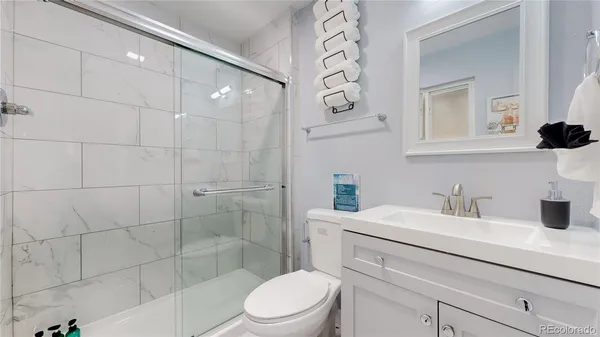 a bathroom with a sink a toilet and shower