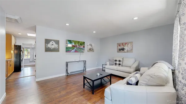 a living room with furniture and a wooden floor