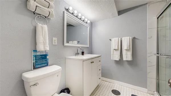 a bathroom with a sink a toilet and shower