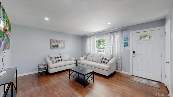 a living room with furniture and a wooden floor