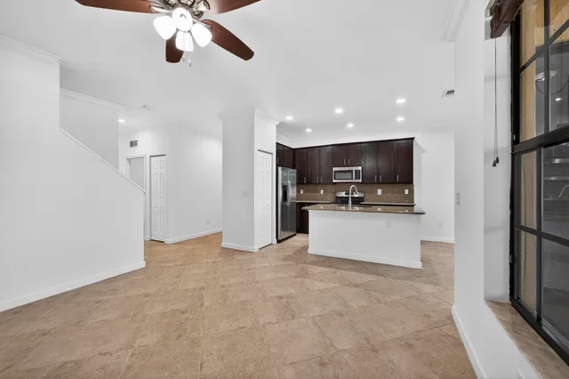 a kitchen with stainless steel appliances granite countertop a sink and a refrigerator