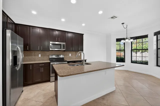 a kitchen with stainless steel appliances granite countertop a stove refrigerator and microwave