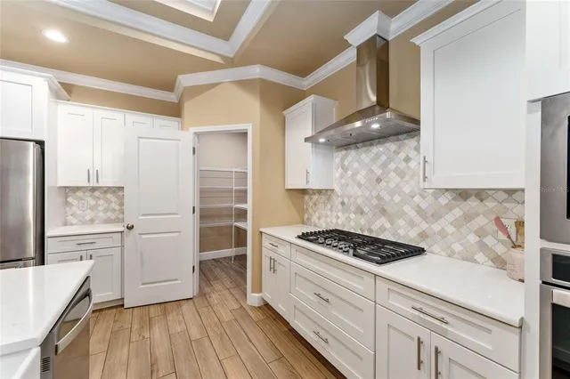 a kitchen with white cabinets and appliances