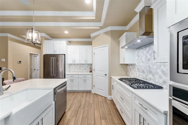 a dining room with furniture a chandelier and wooden floor
