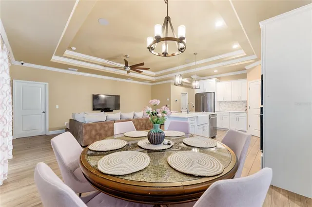 a dining room with furniture a chandelier and wooden floor