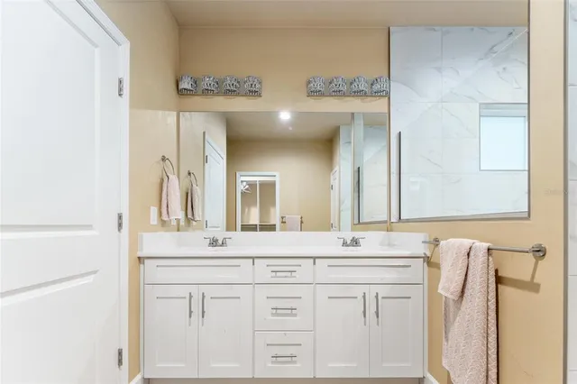 a bathroom with a double vanity sink mirror and shower