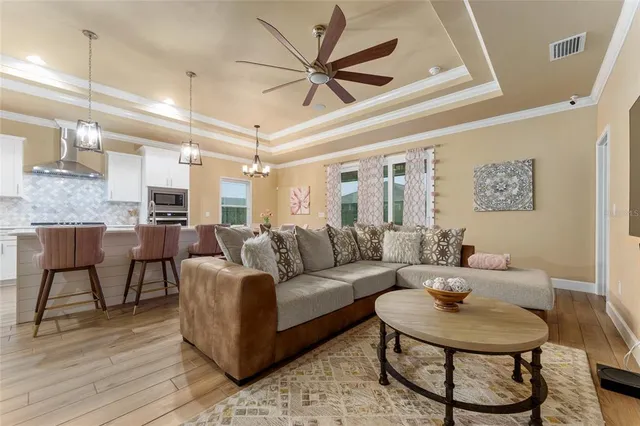 a kitchen with granite countertop a stove a sink dishwasher a dining table and chairs with wooden floor