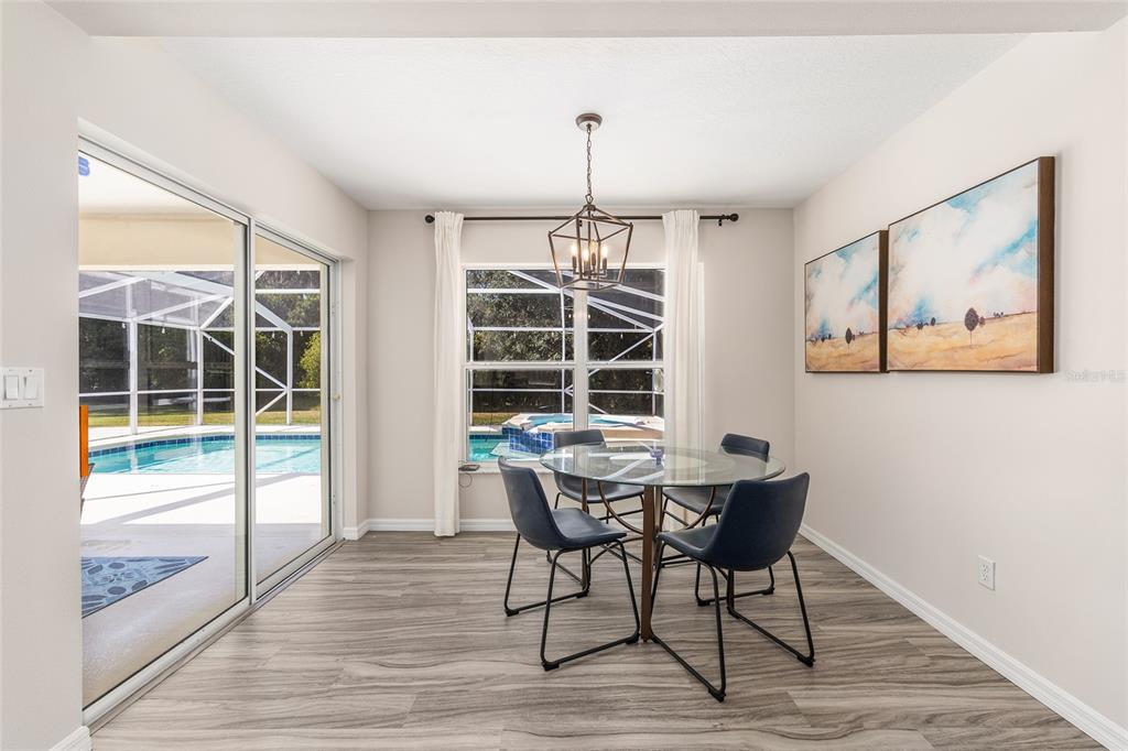 5248 Northwest 82nd Court Ocala, FL 34482 - Photo 22 of 73 a dining room with wooden floor a glass table and chairs