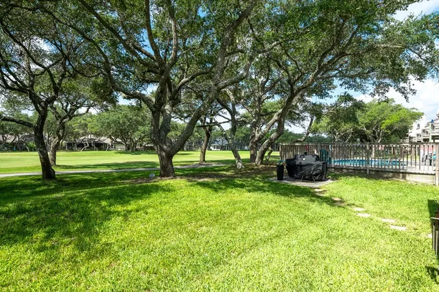 a view of a house with a big yard and large trees