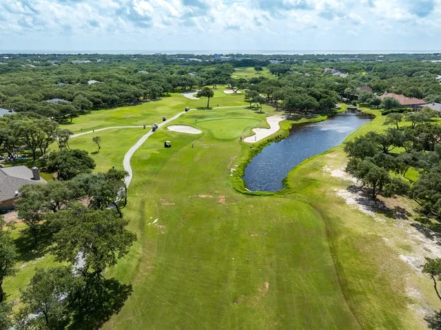 an aerial view of residential houses with outdoor space and trees all around