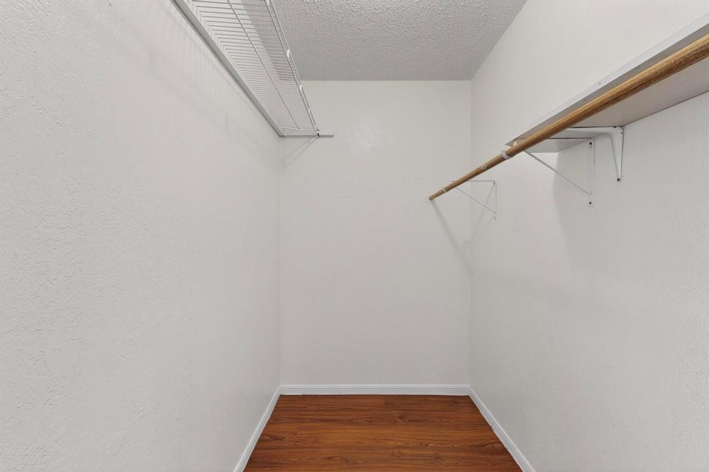 8545 Midpark Road, Unit 16 Dallas, TX 75240 - Photo 10 of 29 Walk in closet with dark wood-style floors