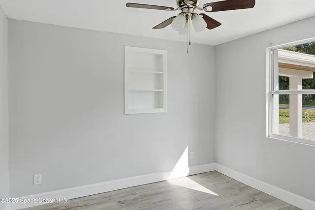 wooden floor in an empty room with a window