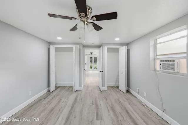 a view of empty room with wooden floor