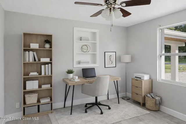 a view of a workspace with furniture and a bookshelf