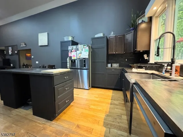 a kitchen with kitchen island granite countertop a sink stove and cabinets