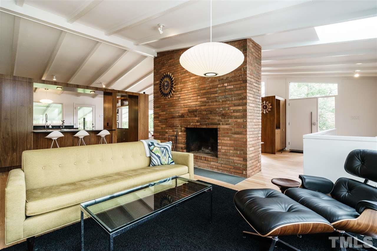 3322 Ocotea Street Raleigh, NC 27607 - Photo 12 of 25 a living room with furniture a fireplace and a chandelier