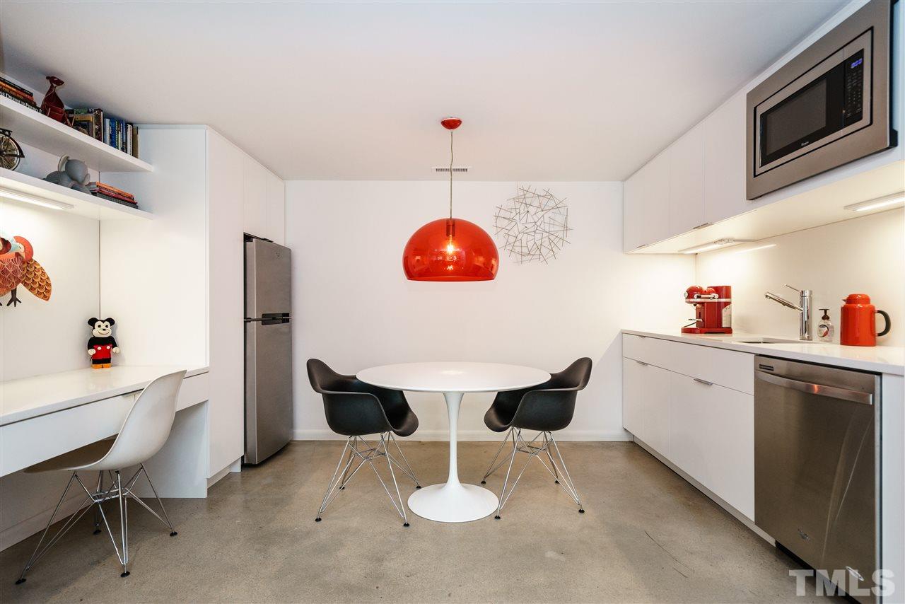 3322 Ocotea Street Raleigh, NC 27607 - Photo 20 of 25 a kitchen with a dining table cabinets and stainless steel appliances