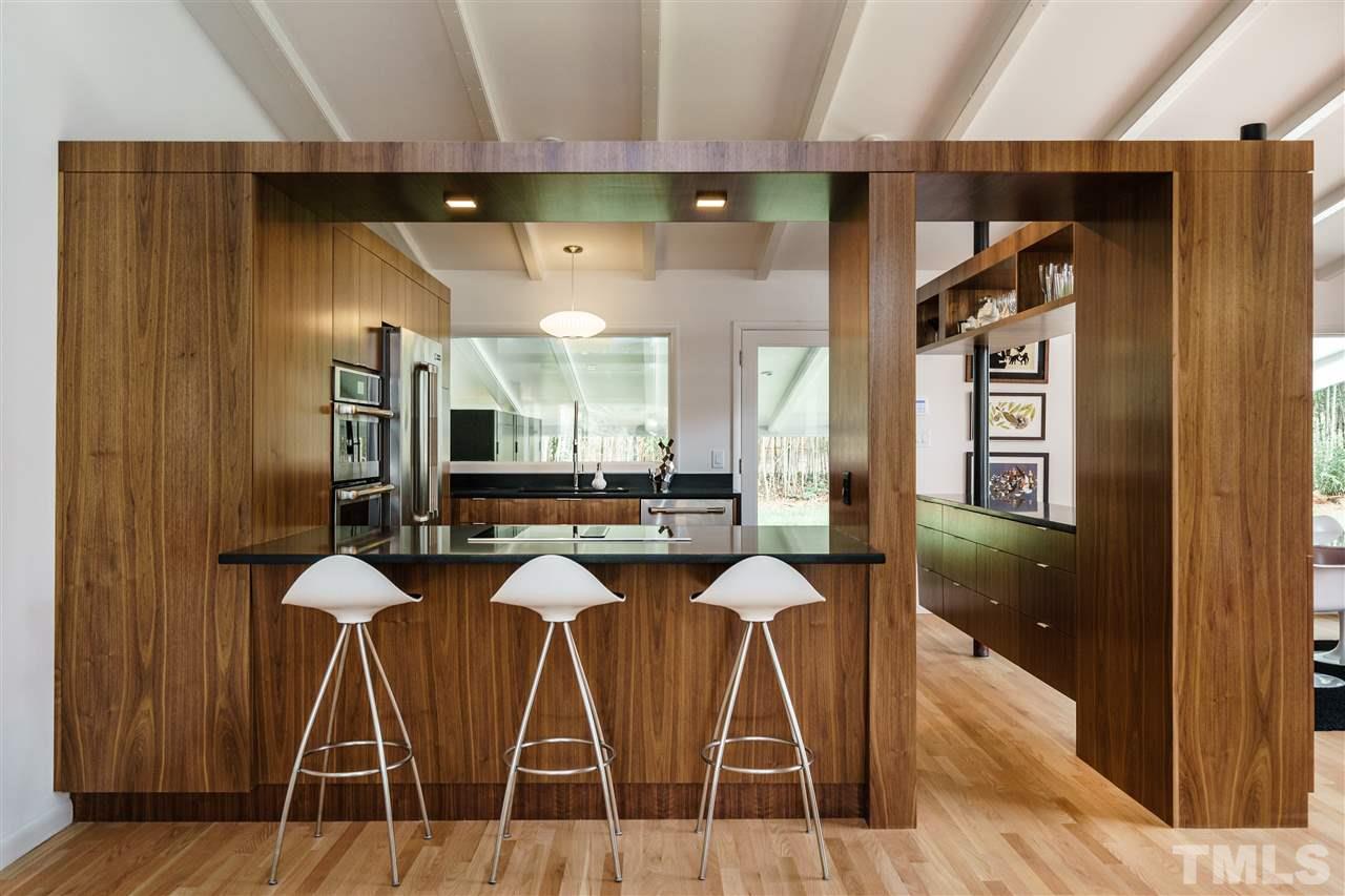 3322 Ocotea Street Raleigh, NC 27607 - Photo 4 of 25 a dining room with kitchen island a table and chairs