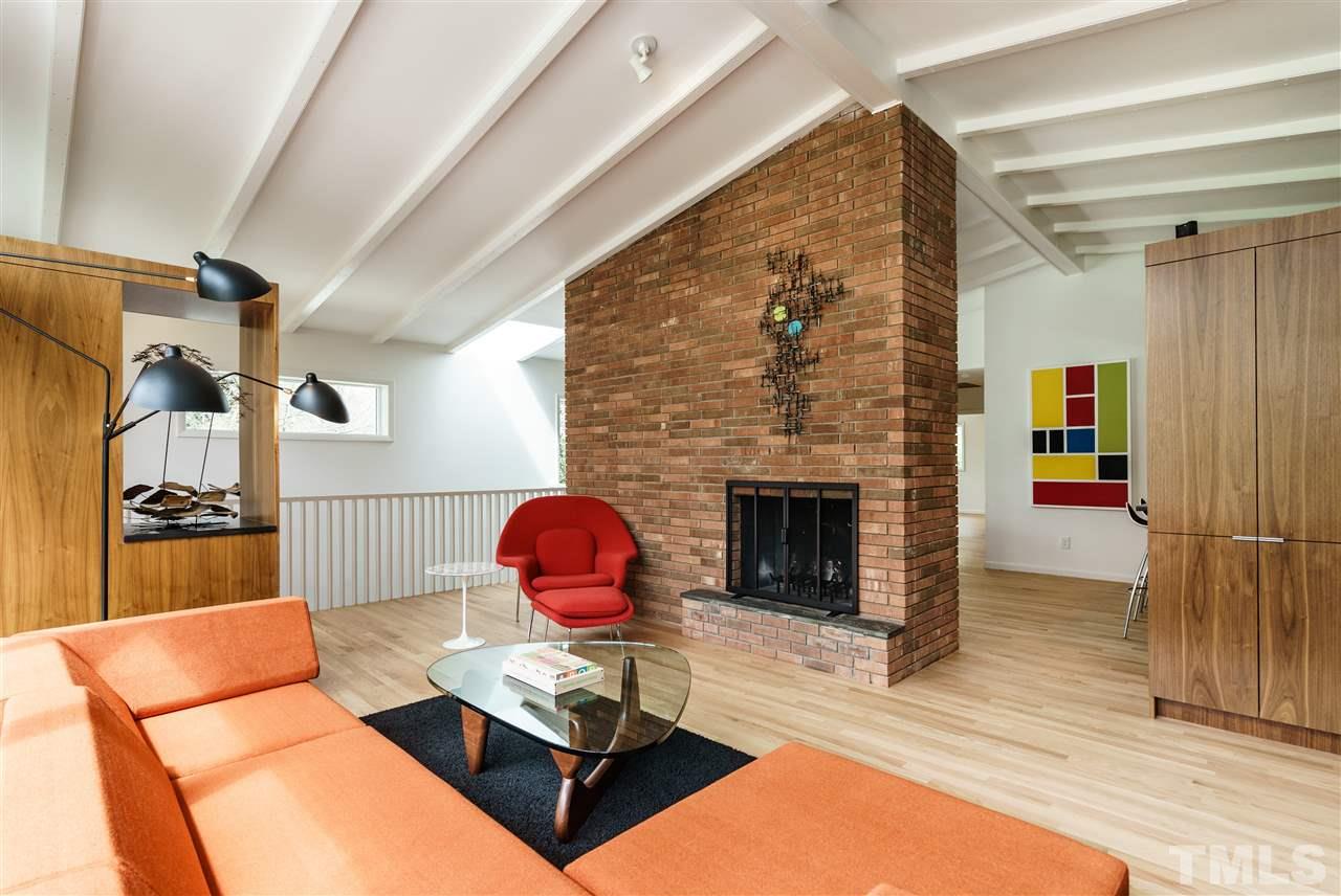 3322 Ocotea Street Raleigh, NC 27607 - Photo 10 of 25 a living room with furniture a fireplace and a table