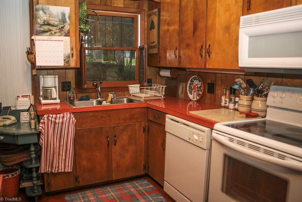 47 Ridge Road Glade Valley, NC 28627 - Photo 15 of 25 The window over the kitchen sink gives you a nice view of the front yard. The kitchen has a stainless steel sink, dishwasher, stove, built in microwave, and refrigerator. It has beautiful red linoleum floors which compliment the decor in the rest of the main level of the home.