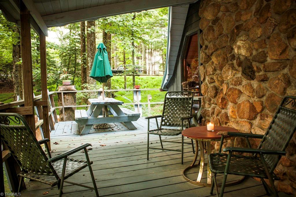 47 Ridge Road Glade Valley, NC 28627 - Photo 23 of 25 The large wrap around deck features a picnic table and has room for lots of chairs and side tables. Perfect for entertaining. A portion of the deck is covered so you can use anytime.