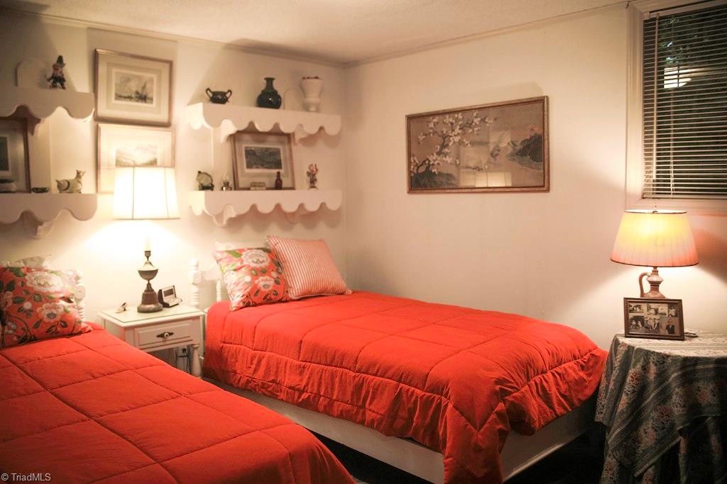 47 Ridge Road Glade Valley, NC 28627 - Photo 24 of 25 Lower level bedroom with twin beds. This level has carpeted floors, and a big stone fireplace.