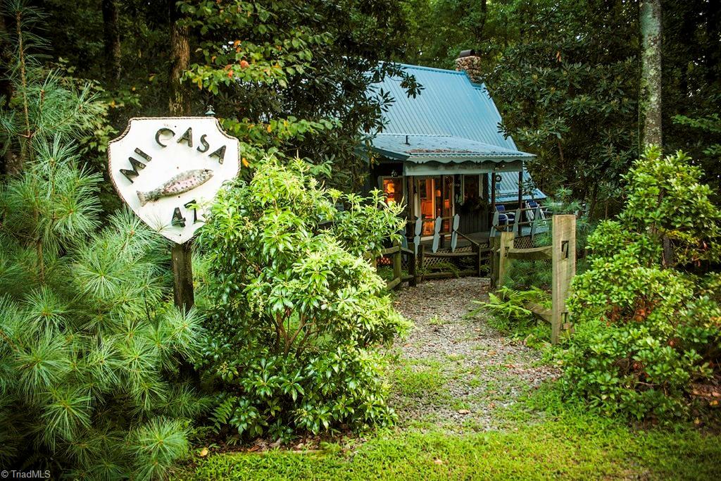 47 Ridge Road Glade Valley, NC 28627 - Photo 4 of 25 A charming walkway leads you from the parking area in front, to this charming mountain retreat. Look for the Mi Casa sign to know you have arrived! Take in the beautiful landscaping on your way up the walk.