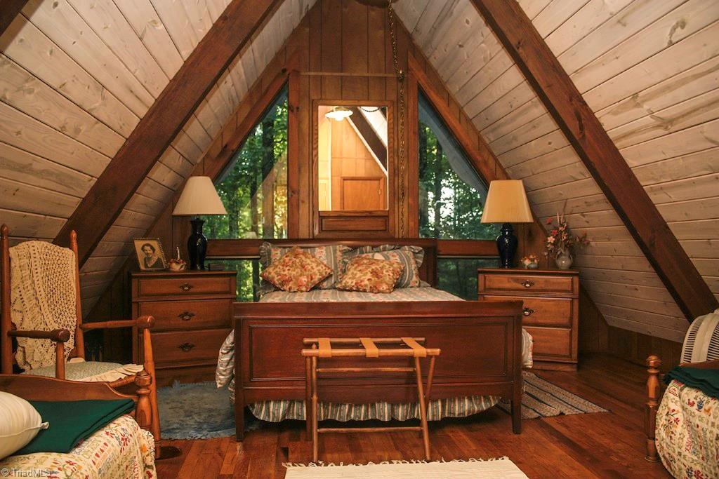 47 Ridge Road Glade Valley, NC 28627 - Photo 10 of 25 One of the upstairs bedrooms which features the charming wood of the A Frame walls and hardwood floors. This room is large enough to sleep 4. Perfect for weekend visitors, or a large family.