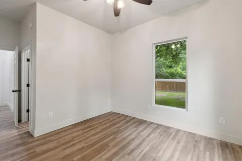 an empty room with a window and wooden floor