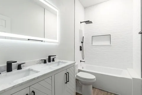a bathroom with a sink a toilet and shower