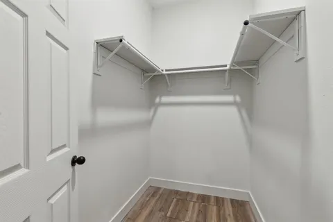 a view of walk in closet with empty racks