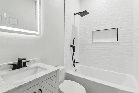 a bathroom with a sink toilet vanity and bathtub