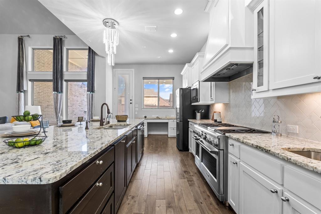 2812 Orchid Street Carrollton, TX 75007 - Photo 11 of 39 Kitchen featuring white cabinetry, light stone countertops, stainless steel appliances, tasteful backsplash, and recessed lighting