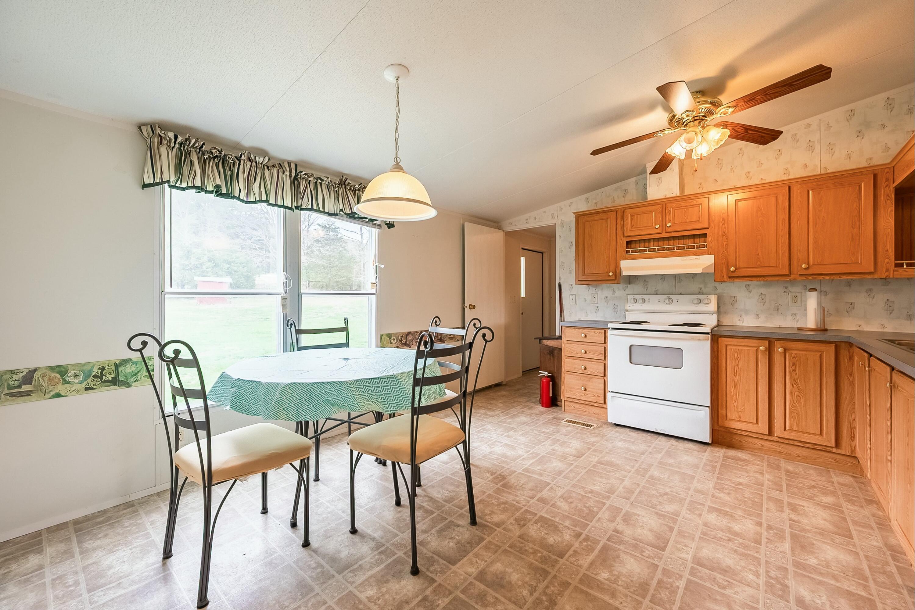 3588 Flatwoods Road Elliston, VA 24087 - Photo 14 of 119 a kitchen with stainless steel appliances kitchen island granite countertop a table chairs in it and wooden floors