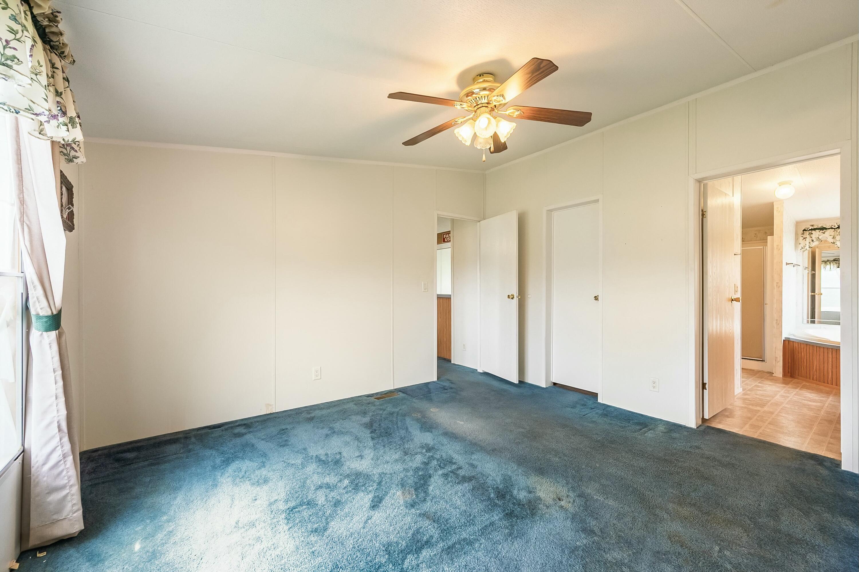 3588 Flatwoods Road Elliston, VA 24087 - Photo 36 of 119 an empty room with wooden floor chandelier fan and windows