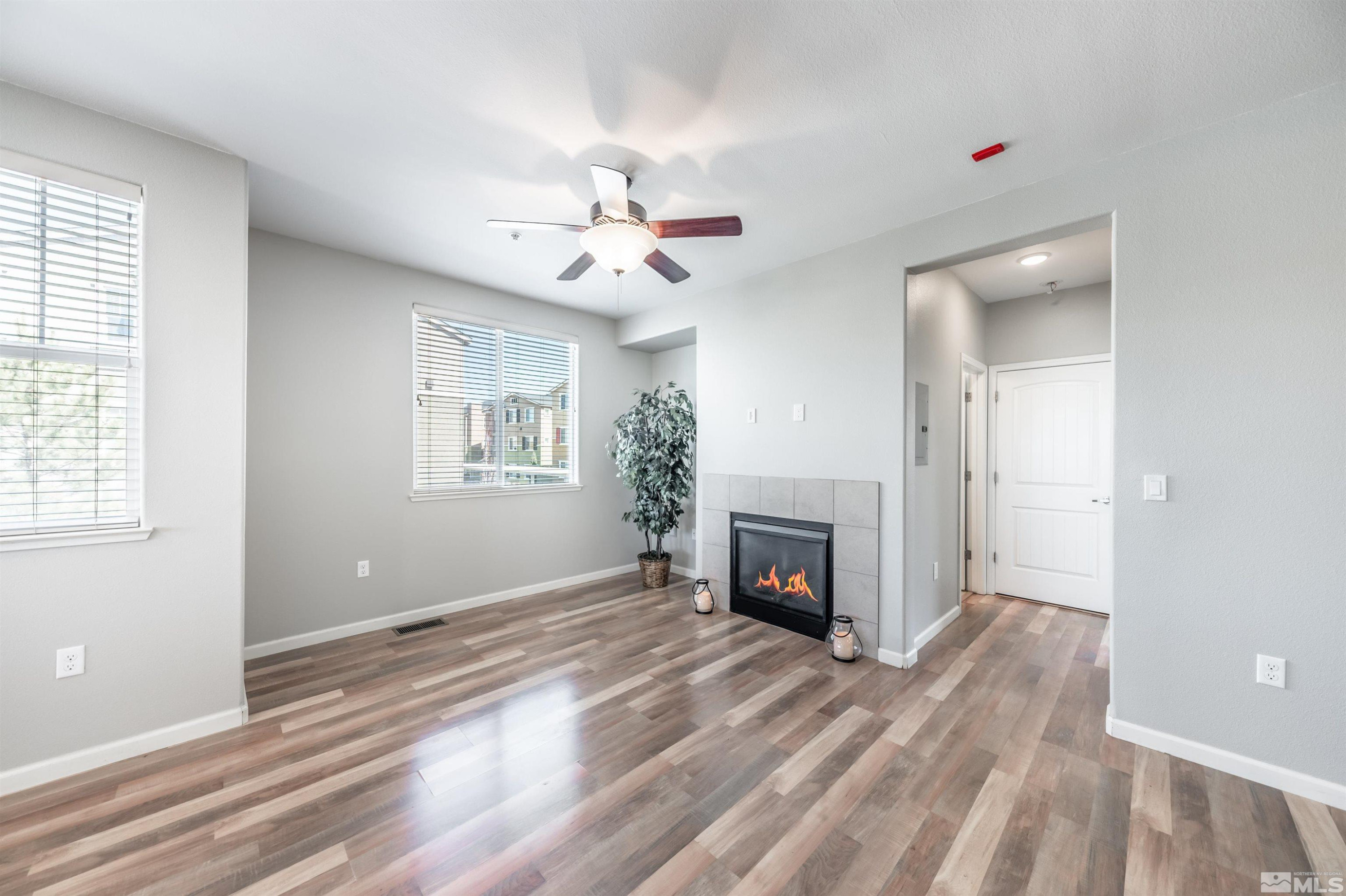 2490 Eastshore Place, Unit 602 Reno, NV 89509 - Photo 11 of 36 a view of a livingroom with a fireplace a ceiling fan and windows