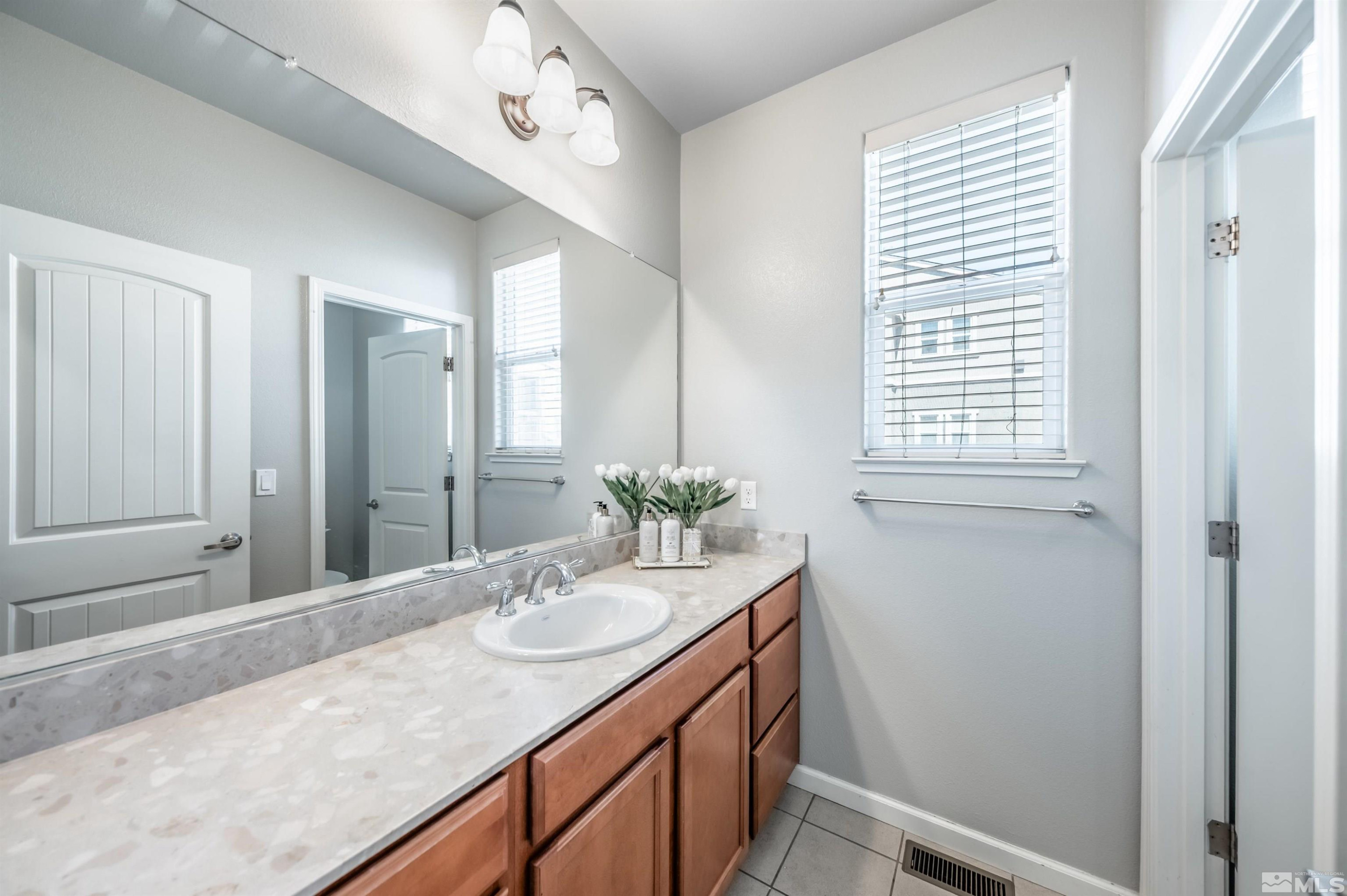 2490 Eastshore Place, Unit 602 Reno, NV 89509 - Photo 23 of 36 a bathroom with a granite countertop sink a mirror and a bathtub