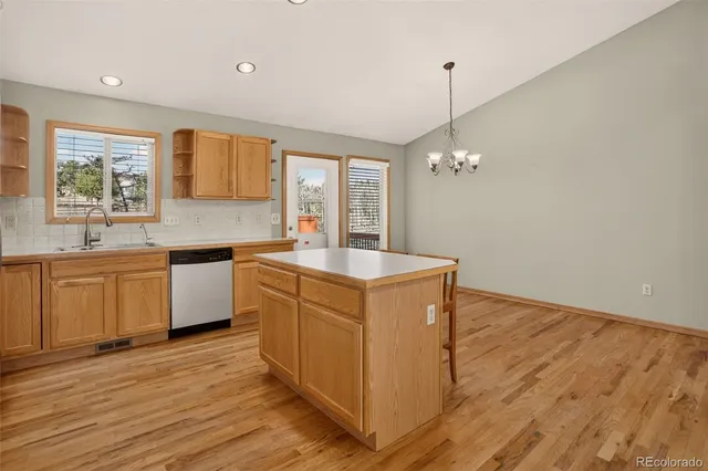 a kitchen with wooden floors and white cabinets