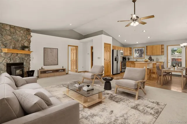 a living room with furniture kitchen view and a fireplace