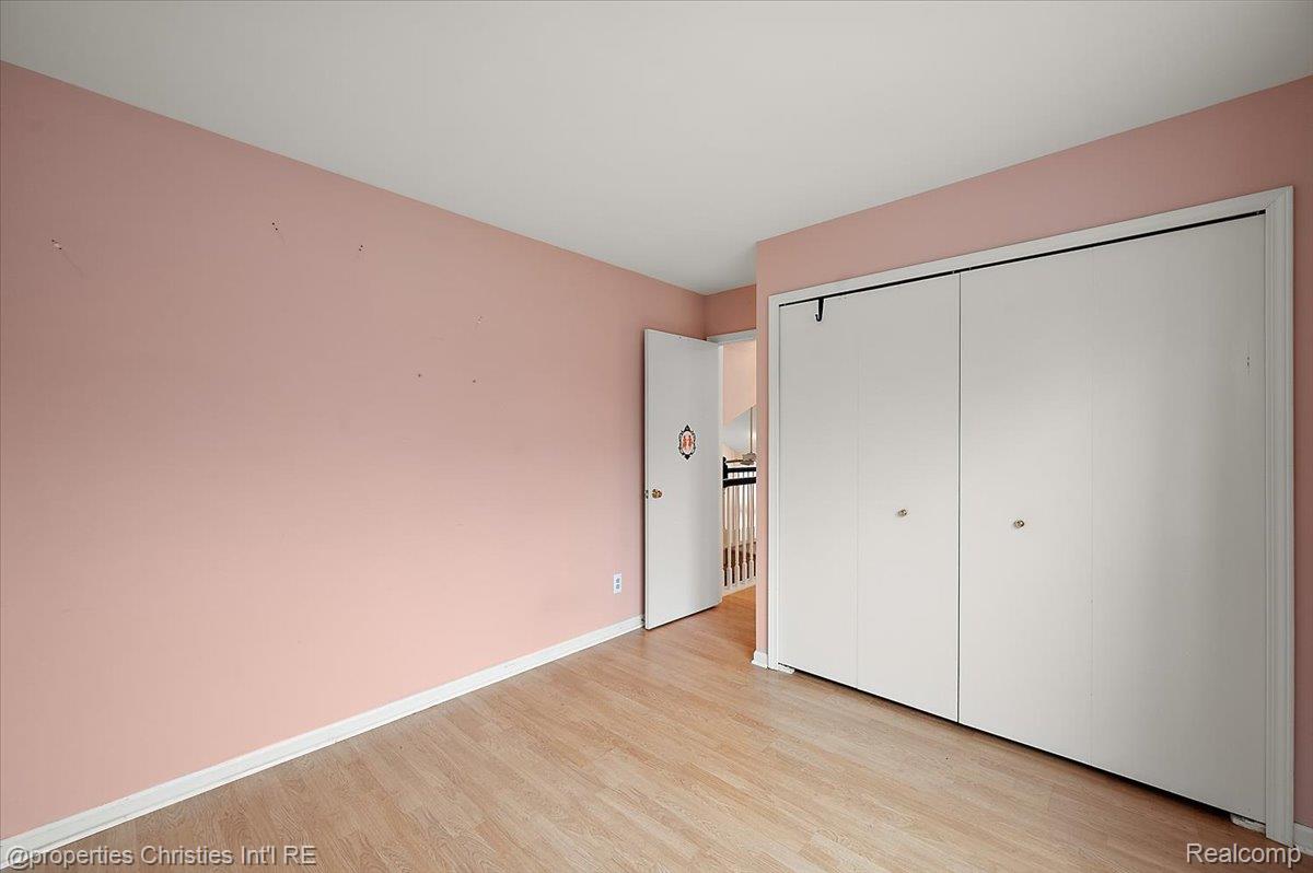 955 Rikki Ann Court Wixom, MI 48393 - Photo 48 of 54 Unfurnished bedroom featuring light wood-type flooring and a closet