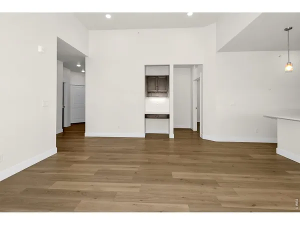 a view of empty room with wooden floor